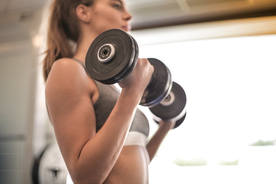 Fit Female in Activewear Holding Dumbbells